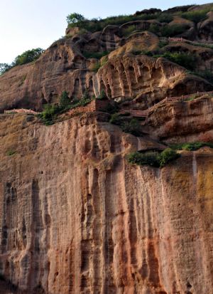 Photo taken on August 14, 2009 shows craggedness of the cliffs in the Huoshizhai National Geopark in northwest China's Ningxia Hui Autonomous Region. The geopark is famous for its unique 'Danxia' landform. Danxia, which means 'rosy cloud', is a kind of special landform formed from reddish sandstone that has been eroded over time into a series of mountains surrounded by curvaceous cliffs and many unusual rock formations.