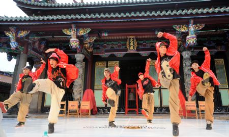 Members of the dance troupe Buzztop dance in front of the Confucian Temple in Taipei of southeast China's Taiwan province, on August 16, 2009.