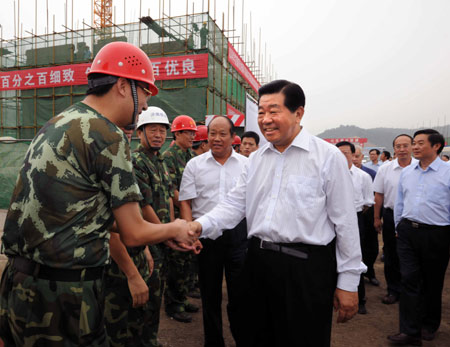 Jia Qinglin (C), chairman of the National Committee of the Chinese People's Political Consultative Conference (CPPCC), shakes hands with workers at the building site of residential houses in the new county seat for the quake-hit Beichuan County of southwest China's Sichuan Province, on August 16, 2009.