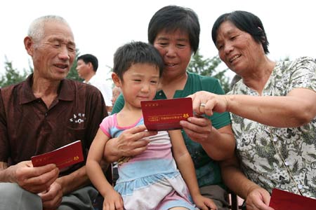 Old farmers get together and share the joy of receiving their old-age pension in Shouguang, east China&apos;s Shandong Province, on August 19, 2009. Some 192 old farmers, the initial batch of them in Shouguang area received on Wednesday the social basic old-age pension under the new insurance system for rural area people