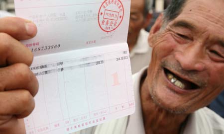 An old farmer shows his old-age pension in Shouguang, east China&apos;s Shandong Province, on August 19, 2009. Some 192 old farmers, the initial batch of them in Shouguang area received on Wednesday the social basic old-age pension under the new insurance system for rural area people.