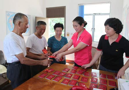 Old farmers receive their old-age pension in Tongling, east China&apos;s Anhui Province, on August 19, 2009. Some 6200 farmers, the initial batch of them in Tongling area would receive the social basic pension by the end of this month under the new insurance system for rural area people.