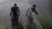 Children seek relief from a heat wave in the fountains near the Eiffel Tower in Paris, capital of France, on August 19, 2009. Seven provinces in France are under a heatwave alert on Wednesday with temperature in Paris climbed to 35 degrees Celsius.