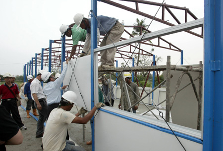 Construction workers assemble the first shipment of prefab houses donated by mainland China for survivors of typhoon Moraket at Jiadong Township near Pingtung County in southeast China's Taiwan Province, on August 20, 2009.