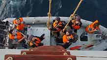 Chinese naval soldiers climb down the ladder from the larboard of Zhoushan missile frigate of the Chinese escort flotilla to the yacht to protect merchant vessel 'Zhenhua 14' from pirates in the Aden Gulf, on August 20, 2009.