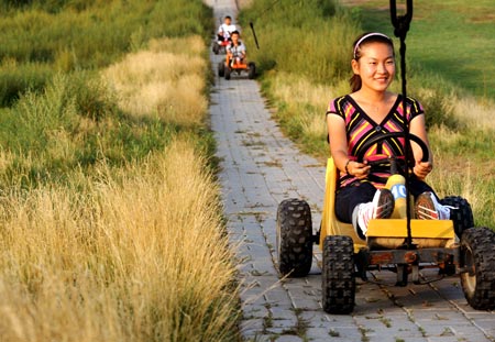 Tourists enjoy themselves in a grassland in Baotou City, north China's Inner Mongolia Autonomous Region, on August 19, 2009. 