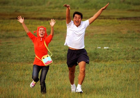 Tourists enjoy themselves in a grassland in Baotou City, north China's Inner Mongolia Autonomous Region, on August 19, 2009. 