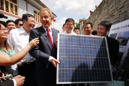 Former British Prime Minister Tony Blair (4th R front row) and Chinese actor Jet Li (1st R front row) hold a solar panel at Baigongzhai Village in Guiyang, capital of southwest China's Guizhou Province, on August 22, 2009. Blair and Jet Li are invited to attend a conference on environment protection in Guiyang and they started a project of solar-powered-LED lighting in the countryside. 