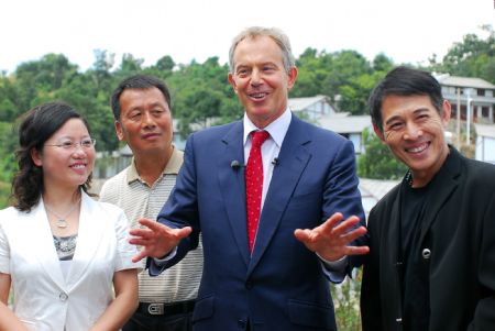 Former British Prime Minister Tony Blair (2nd R) and Chinese actor Jet Li (1st R) talk with local staff at Baigongzhai Village in Guiyang, capital of southwest China's Guizhou Province, on August 22, 2009.