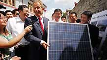 Former British Prime Minister Tony Blair (4th R front row) and Chinese actor Jet Li (1st R front row) hold a solar panel at Baigongzhai Village in Guiyang, capital of southwest China's Guizhou Province, on August 22, 2009. Blair and Jet Li are invited to attend a conference on environment protection in Guiyang and they started a project of solar-powered-LED lighting in the countryside.
