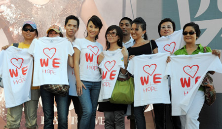 Pop singer Coco Lee (C) poses for photos with fans on a promotion event of her new album in Taipei, southeast China's Taiwan Province, August 23, 2009, during which she raises donations for the typhoon Morakot hit area in Taiwan by rummage sales of T-shirts designed by herself with a designing group.