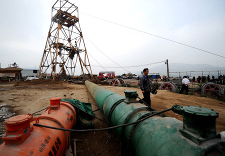 A man walks past a wind tube sending wind to a pit where a blast of a coial mine took place in Heshun County, north China's Shanxi Province, August 25, 2009, as rescue works are continuing. Eleven people have been killed, three are missing and two survived following a gas blast in the Xingguang Coal Company Ltd. here at about 11:10 AM on Monday, the local authorities said.
