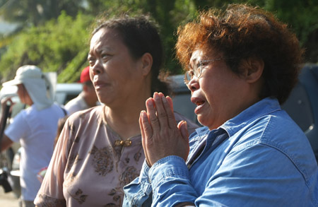 Relatives mourn for their victims in front of mudslide area at the devastated village of Hsiaolin, in Kaohsiung county, southeast China's Taiwan Province, August 15, 2009.