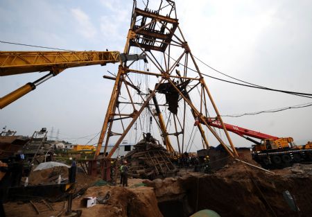 Rescuers clean up the falling objects from the entrance of a well at the site of the gas blast in Heshun County in Jinzhong City, north China's Shanxi Province, on AugUST 25, 2009.