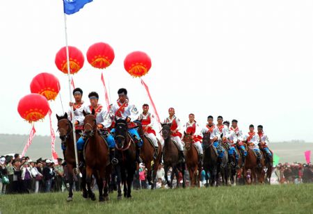 A row of cavaliers riding horses parade into the competition fields during the opening ceremony of the first traditional sports meeting of the ethnic groups of Baotou City, north China's Inner Mongolia Autonomous Region, August 25, 2009. 