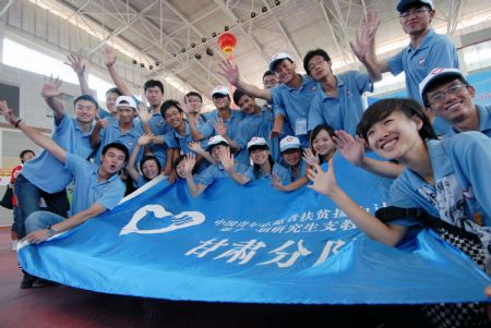 Postgraduates who are about to set out on their obligation as assisting tutors to Gansu Province pose for a group photo in Guiyang, southwest China's Guizhou Province, August 25, 2009.