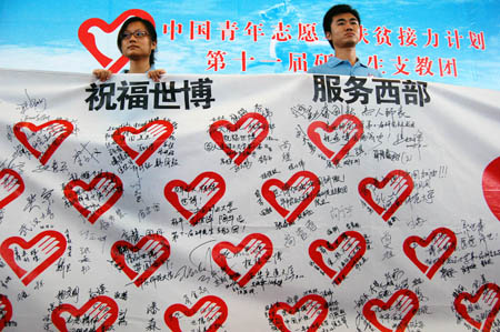 Two postgraduate volunteers unfurl the streamer with the collective signatures of volunteers who are about to set out on their obligation as assisting tutors during the setting-off ceremony, in Guiyang, southwest China's Guizhou Province, August 25, 2009.