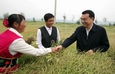 Chinese Vice Premier Li Keqiang (R) talks with villagers of Hongju Village, Huzhu Tu Autonomous County, northwest China's Qinghai Province, August 24, 2009. Li Keqiang inspected Qinghai Province from August 23 to August 25.