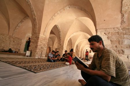 Palestinian people read the Koran during the holy fasting month of Ramadan in Al-Omari mosque in Gaza City on August 26, 2009.