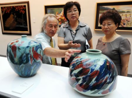 People view porcelains on the Craft Taiwan 2009 in Taipei, southeast China's Taiwan Province, August 27, 2009. The Craft Taiwan 2009 will open to the public on Friday with over 100 craftwork from nearly 60 artists on shown. The income of charity sale during the Craft Taiwan 2009 will be donated to the area hit by typhoon Morakot in Taiwan.