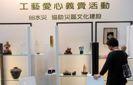 A woman stands by the craftwork at the charity sale zone on the Craft Taiwan 2009 in Taipei, southeast China's Taiwan Province, August 27, 2009. The Craft Taiwan 2009 will open to the public on Friday with over 100 craftwork from nearly 60 artists on shown. The income of charity sale during the Craft Taiwan 2009 will be donated to the area hit by typhoon Morakot in Taiwan. 