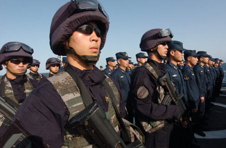 Chinese naval soldiers and officers of the Chinese escort flotilla attend the starting ceremony of the 100th escort mission on Zhoushan missile frigate in the eastern waters of the Gulf of Aden, Aug. 27, 2009. (Xinhua/Guo Gang)