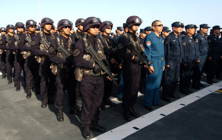 Chinese naval soldiers and officers of the Chinese escort flotilla attend the starting ceremony of the 100th escort mission on Zhoushan missile frigate in the eastern waters of the Gulf of Aden, Aug. 27, 2009. (Xinhua/Guo Gang)