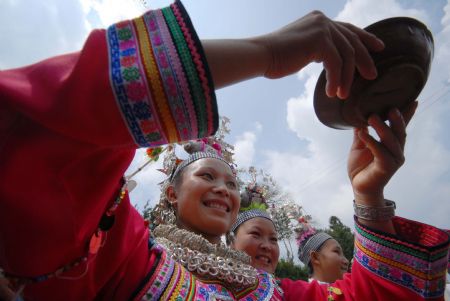 A girl sings a song when serving wine to the guest at the Chixin Festival, or New Grain Tasting Festival, in a village of the Miao ethnic group in Duyu City of southwest China's Guizhou Province, August 28, 2009. 