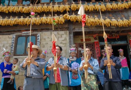 Villagers of the Miao ethnic group play the Lusheng, a local reed-pipe musical instrument, at the Chixin Festival, or New Grain Tasting Festival, in a village of the Miao ethnic group in Duyu City of southwest China's Guizhou Province, August 28, 2009.