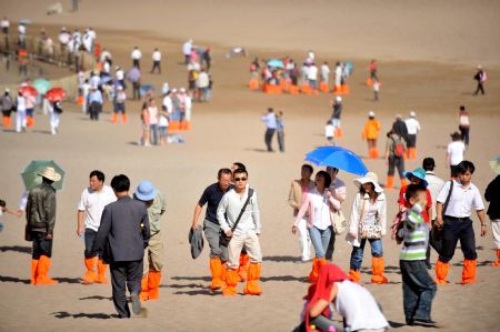 Tourists look around in Dunhuang, northwest China's Gansu Province, August 30, 2009. 