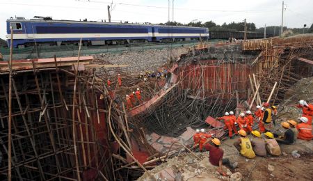 A train passes the scene of a bridge collapse accident in Guiyang, southwest China's Guizhou Province, August 31, 2009.