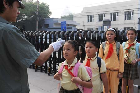 Students of Beijing No. 2 Experiment Primary School queue for temprerature check at the school gate in Beijing, China, on September 1, 2009. Middle schools and primary schools started the new semester in China on Tuesday.