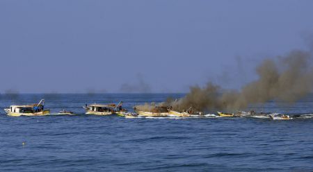 Smokes rise from a Palestinian boat off western Gaza city shore after being hit by an Israeli shell, August 31, 2009.