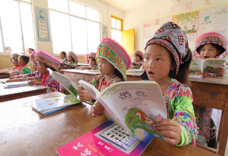 Girl students of a Hope School read their new school books in Longlin county, southwest China&apos;s Guangxi Zhuang Autonomous Region, August 31, 2009. Some 57,000 poor students in rural areas in Longlin county would receive free textbooks. (Xinhua/Lin Bin)