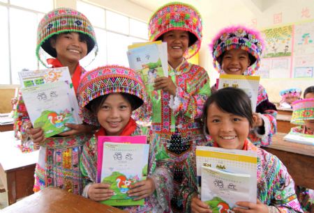 Minority girl students of a Hope School show their free new school books in Longlin county, southwest China&apos;s Guangxi Zhuang Autonomous Region, August 31, 2009.(Xinhua/Lin Bin)
