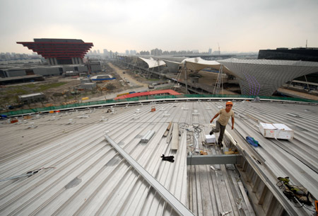 A worker is seen at the roof of the Performance Center of the World Expo 2010 under construction in Shanghai, east China, Aug. 31, 2009. The permanent facilities including the World Expo Axis, Chinese Pavilion, Theme Pavilion, Performance Center and Expo Center of the World Expo 2010, will be completed by the end of this year.(Xinhua Photo)