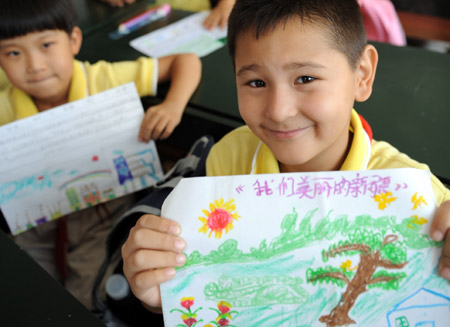 Students from the 3rd Grade of Urumqi No. 10 Primary School display their drawings named &apos;My Beautiful Xinjiang&apos; on the first day of the new semester in Urumqi, capital of northwest China&apos;s Xinjiang Uygur Autonomous Region, September 1, 2009. Middle schools and primary schools started the new semester in China on Tuesday. 