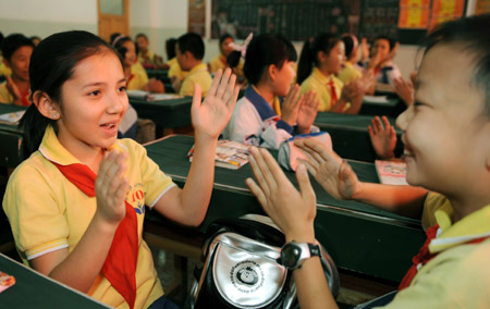 Student of Uygur nationality and Han nationality sing a song at Urumqi No. 10 Primary School on the first day of the new semester in Urumqi, capital of northwest China&apos;s Xinjiang Uygur Autonomous Region, September 1, 2009. 