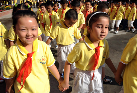 Students from Urumqi No. 10 Primary School walk to classrooms on the first day of the new semester in Urumqi, capital of northwest China&apos;s Xinjiang Uygur Autonomous Region, September 1, 2009. 