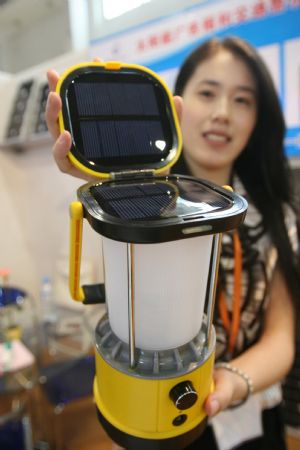 An exhibitor presents a novel solar energy bivouac lamp with multifunction of illumination, compass and recharging for mobile phone, at the 3-day-long 2009 China International Pneumatic, Solar and Nuclear Power Industry, concurrently Electric Power and Electrician Equipment and Technology Exposition, which is held at the China International Exhibition Center, drawing some 800 enterprises from both China and overseas, at Beijing, September 2, 2009.
