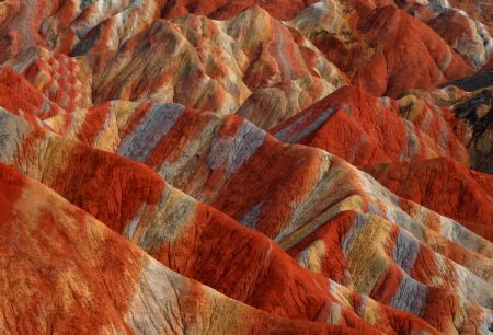 The file picture taken on July 26, 2009 shows the unique hilly terrain with red rocks and cliffs of the Danxia Landform in the mountainous areas of the Zhangye Geology Park near the city of Zhangye in northwest China's Gansu Province. Danxia Landform belongs to red terrestrial clastic rock landform, which is characterized by its red cliffed scarp.
