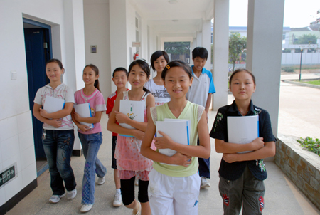 Students step into the new classrooms on campus of Wenwei Middle School, which is financed by Hong Kong-based Wenweipo Newspaper with a fund-raising of 4 million HK dollars to replace the old schools that were severely ravaged during the May 12 massive earthquake last year, in Danling County, southwest China's Sichuan Province, September 2, 2009. 