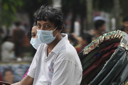 A young couple in a rickshaw wear the masks in Dhaka, capital of Bangladesh, September 3, 2009.