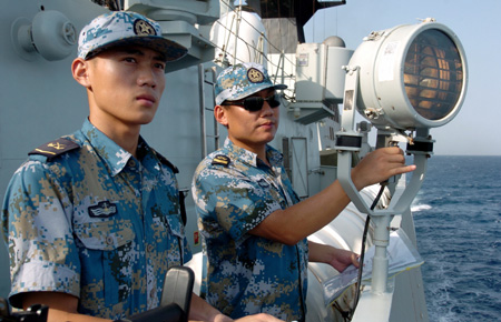 Chinese Navy soldiers aboard Zhoushan missile frigate convey messages via light signals to a Russian naval vessel on the Gulf of Aden, on September 2, 2009.