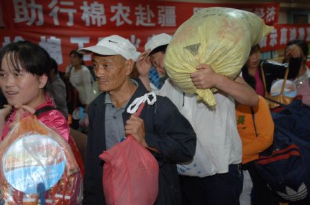 Cotton pickers wait for the train bound for Urumqi of northwest China's Xinjiang Uygur Autonomous Region, at the railway station in Xi'an, northwest China's Shaanxi Province, on September 4, 2009. A special train carrying over 1,700 cotton pickers from Xi'an to Urumqi started at 11:30 PM local time on Friday. The Xi'an Railway Station has prepared special trains for cotton pickers who will participate in the cotton harvest in Xinjiang. 