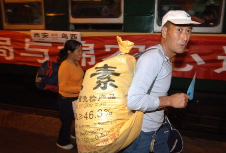 Cotton pickers get on the train bound for Urumqi of northwest China's Xinjiang Uygur Autonomous Region, at the railway station in Xi'an, northwest China's Shaanxi Province, on September 4, 2009.