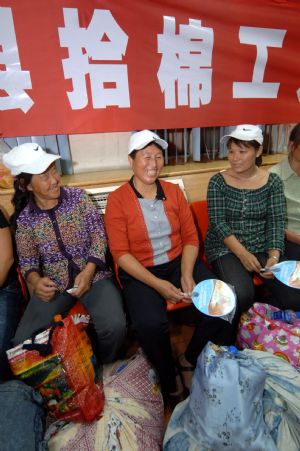 Cotton pickers wait for the train bound for Urumqi of northwest China's Xinjiang Uygur Autonomous Region, at the railway station in Xi'an, northwest China's Shaanxi Province, on September 4, 2009.