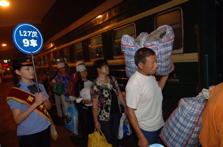 Cotton pickers get on the train bound for Urumqi of northwest China's Xinjiang Uygur Autonomous Region, at the railway station in Xi'an, northwest China's Shaanxi Province, on September 4, 2009.