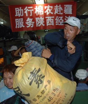 Cotton pickers get on the train bound for Urumqi of northwest China's Xinjiang Uygur Autonomous Region, at the railway station in Xi'an, northwest China's Shaanxi Province, on September 4, 2009.