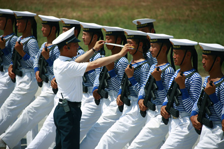 Photo taken on June 28, 2009 shows an officer corrects posture of marines during the parade training in Beijing, capital of China.